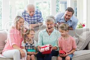 Family opening the surprise gift in living room