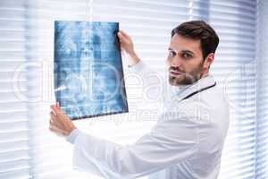 Portrait of male doctor examining x-ray