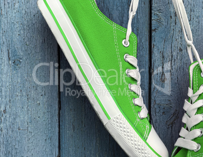 Bright green textile sneakers hanging on the white lace