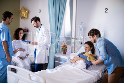 Couple with their newborn baby in the ward