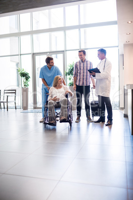 Male doctor talking to pregnant woman in wheelchair