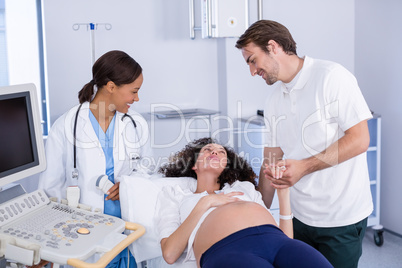 Man comforting pregnant woman during ultrasound