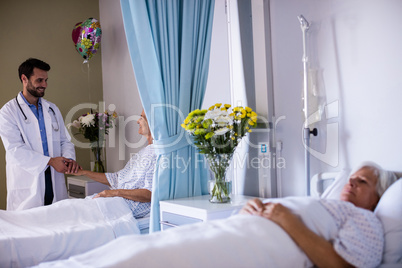 Male doctor examining female senior patient