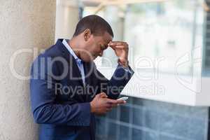 Worried businessman looking at mobile phone
