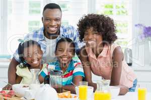 Kids and parents having breakfast on table at home