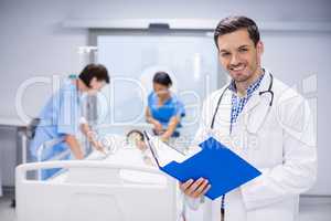 Portrait of doctor writing on clipboard