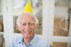 Smiling senior man with party hat