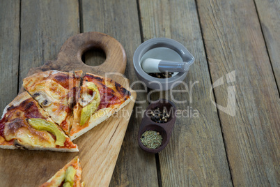 Slices of italian pizza served in a chopping board with ingredients