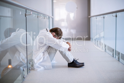 Tensed doctor sitting in corridor