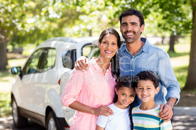 Happy family on a picnic standing next to their car
