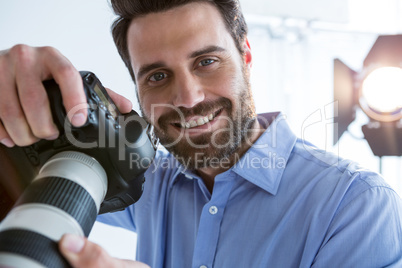 Happy male photographer standing in studio