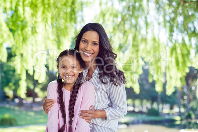 Portrait of a mother standing with her daughter in park