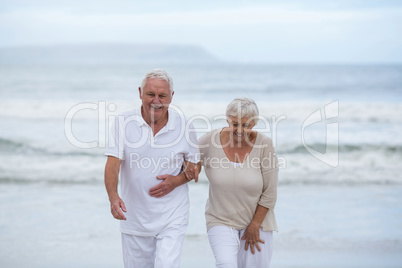 Senior couple walking together on the beach