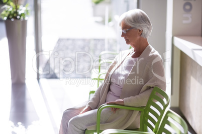 Thoughtful senior woman sitting on chair
