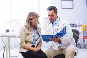 Doctor and senior woman discussing on file