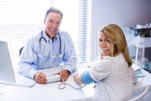 Doctor checking blood pressure of a patient