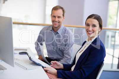 Businesswoman working at desk with colleague