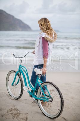 Mature woman standing with bicycle on the beach