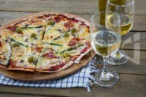 Italian pizza served with wine glasses and ingredients
