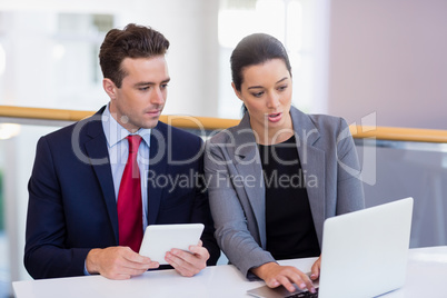 Business executives discussing over laptop