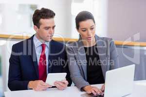Business executives discussing over laptop