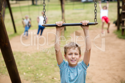 Boy hanging on a playing equipment in park