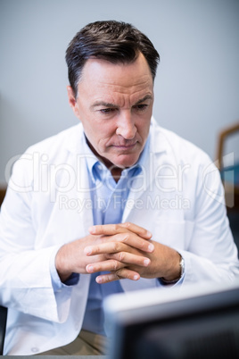 Male doctor looking at personal computer