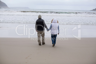 Senior couple walking together on the beach