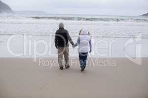 Senior couple walking together on the beach