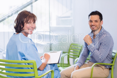 Portrait of nurse discussing a medical report with man