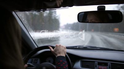 Lovely woman travelling by car on winter road