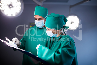 Male and female surgeon checking the medical report of the patient
