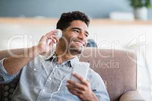Man listening to music on mobile phone in living room