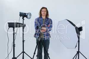 Photographer with hands crossed standing in the photo studio