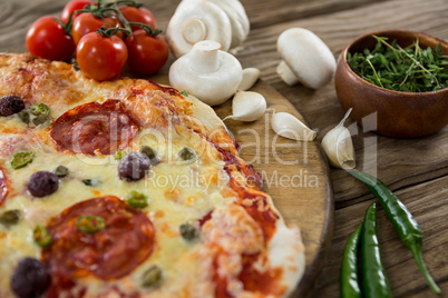 Various species with pizza and tomato on a wooden tray