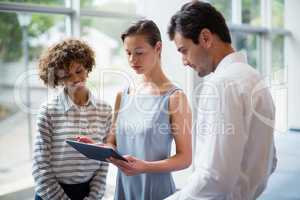 Business executives discussing over digital tablet