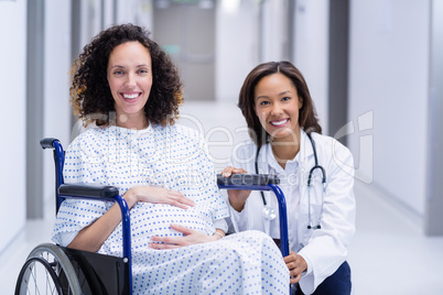 Portrait of doctor and pregnant woman in corridor