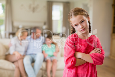 Girl standing with arm crossed in living room