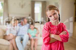 Girl standing with arm crossed in living room