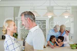 Romantic couple looking face to face at kitchen
