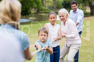 Multi-generation family pulling a rope in tug of war