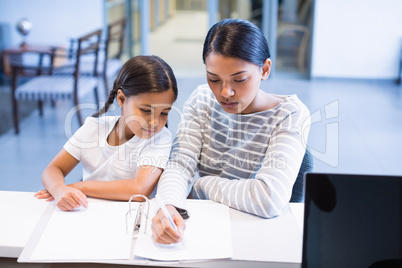 Mother and daughter filling out paperwork at counter