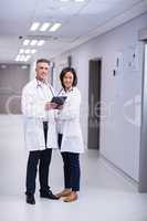 Portrait of doctors using digital tablet in corridor