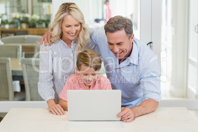Parents and son using laptop at home