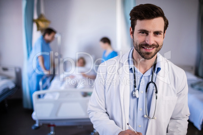 Smiling male doctor standing in hospital