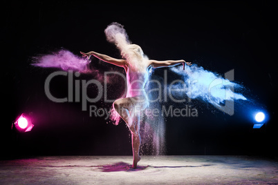 Girl in color dust cloud posing in studio