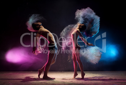 Young couple poses in color dust cloud studio shot