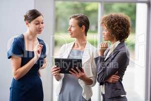 Business executives discussing over digital tablet