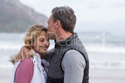 Mature man kissing woman on forehead