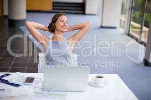 Happy businesswoman relaxing at desk